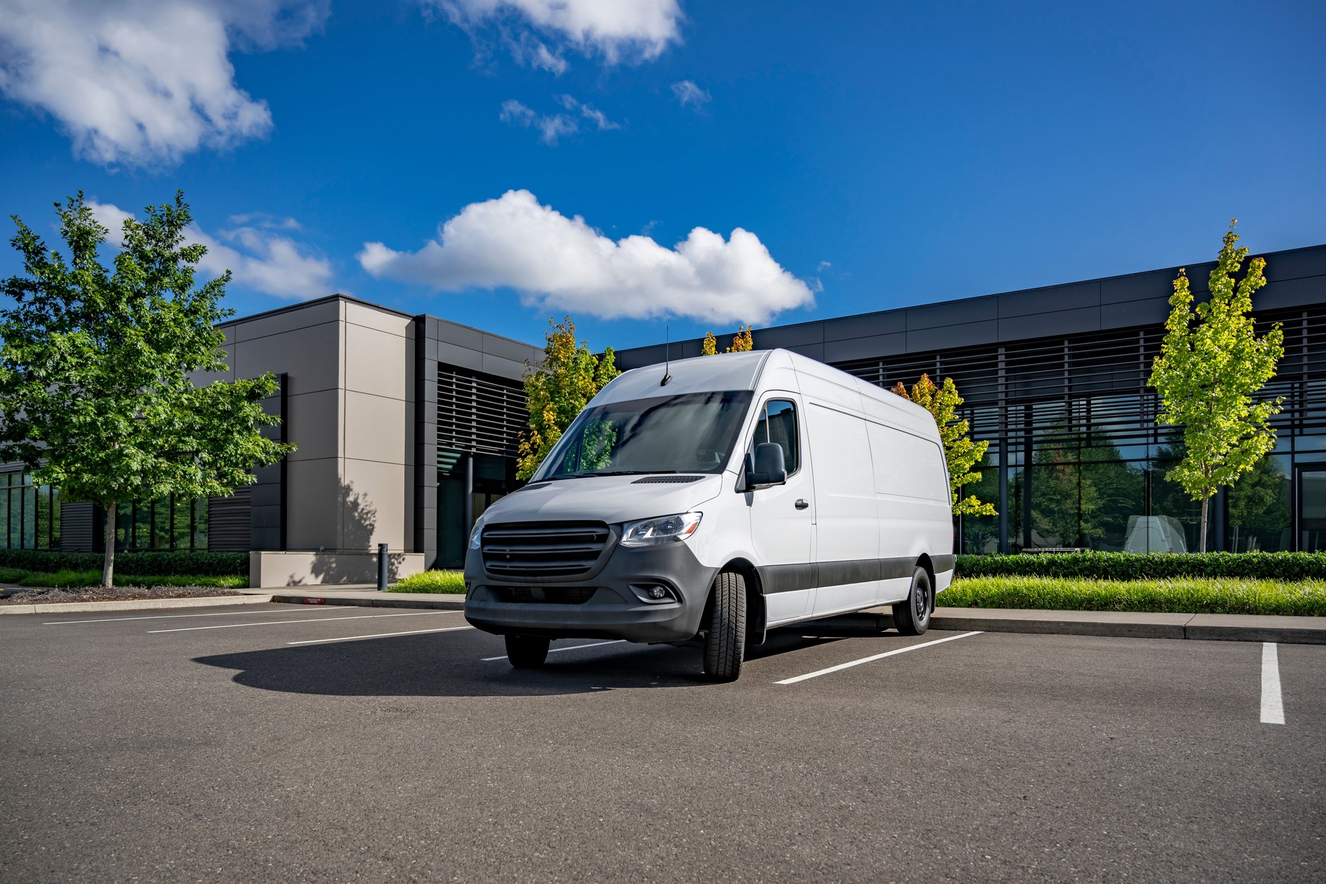 White cargo mini van making delivery to customer work place standing on the industrial parking lot